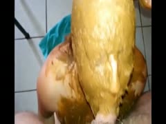 A woman with feces all over her face is sucking her dick.